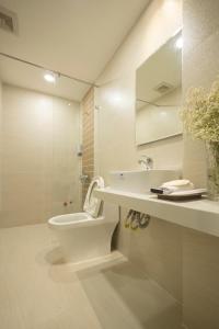 ein weißes Bad mit einem WC und einem Waschbecken in der Unterkunft Karat Home in Ho-Chi-Minh-Stadt