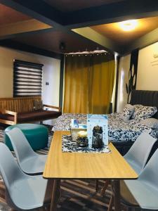 a room with a table and chairs and a bed at Rvenue apartelle in Lucban