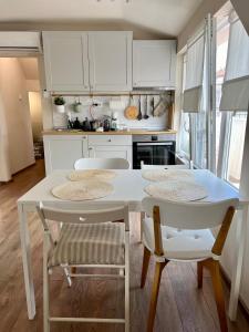 a kitchen with white cabinets and a white table and chairs at Dockview atelier in Burgas City