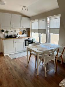 a kitchen with white cabinets and a table and chairs at Dockview atelier in Burgas City