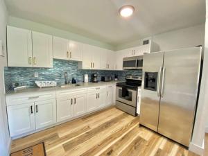a kitchen with white cabinets and a stainless steel refrigerator at Lively Home near Downtown, stadium, Wynwood in Miami