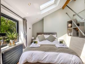 a bedroom with a large bed and a window at Squirrel Cottage in Glossop