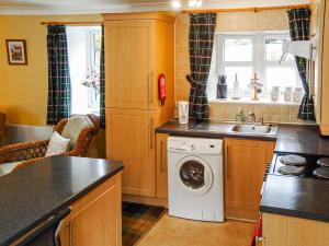 a kitchen with a washing machine and a sink at The Bothy At Willowbank in Grantown on Spey