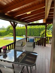 a patio with a table and chairs on a deck at Mazury na Śląsku - Dom Wakacyjny z basenem in Boguchwałowice