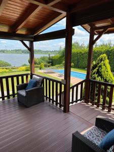 a wooden deck with chairs and a view of a pool at Mazury na Śląsku - Dom Wakacyjny z basenem in Boguchwałowice