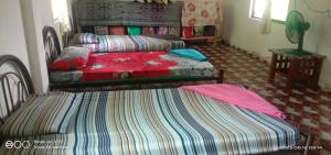 1 dormitorio con 2 camas y sofá en Mulu Helena Homestay en Mulu