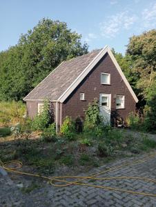 een rood bakstenen gebouw met een huis bij Tiny House Aqualinde in Breda