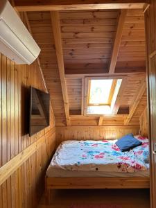Cette chambre comprend un lit dans une cabane en bois. dans l'établissement Mazury na Śląsku, 