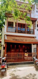 a building with a balcony and a motorcycle parked in front of it at Maison Petite Singapore in Pondicherry