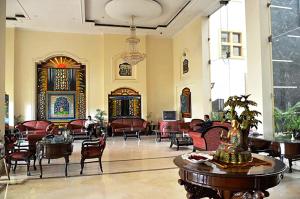 a lobby with chairs and tables in a building at Hotel Meraden Grand in Varanasi