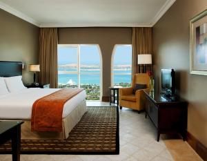 una habitación de hotel con una cama y un televisor en Sheraton Khalidiya Hotel, en Abu Dabi