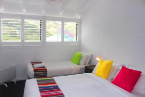 Habitación con 2 camas y almohadas coloridas. en Stillwell Hotel, en Charlotte Pass
