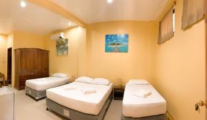 um quarto com 2 camas e um frigorífico em Mabini Hotel em Mambajao