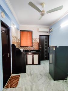 an empty room with a ceiling fan and a kitchen at Hotel Siesta De Goa in Varca