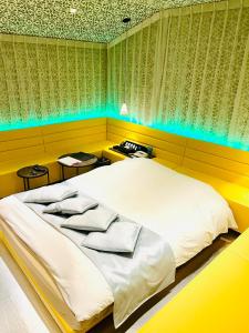 sypialnia z dużym białym łóżkiem z niebieskimi lampkami w obiekcie Asokono Hotel w mieście Kami-seya