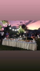 una mesa con comida en ella con una puesta de sol en el fondo en Dipladenia Garden Country Resort en Mascali
