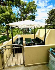 a table and chairs under an umbrella on a patio at MIRTA deluxe SUPERIOR 5 star apartment, your piece of heaven by the sea & park, with sea & park view in Novigrad Istria