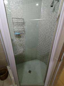 a shower with a glass door in a bathroom at Seaview Apartment Amanzimtoti in Amanzimtoti