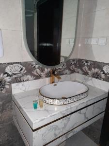 een badkamer met een wastafel en een spiegel bij فلل عائلية بمسابح خاصة in Khamis Mushayt