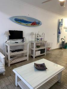 a living room with a table and a surfboard on the wall at Flip-Flops in Jeffreys Bay