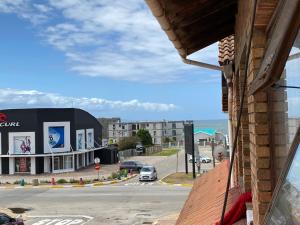 uma vista para uma rua com um edifício e o oceano em Flip-Flops em Jeffreys Bay