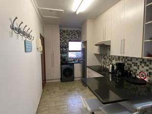 a kitchen with white cabinets and a black counter top at Flip-Flops in Jeffreys Bay