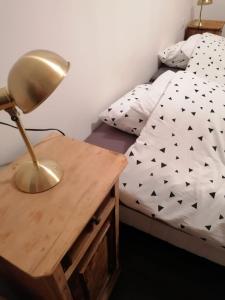a bed with a desk with a lamp on it at LES ANTHOCYANES in Champagny