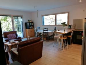 ein Wohnzimmer mit einem Sofa und einem Tisch in der Unterkunft LES ANTHOCYANES in Champagny