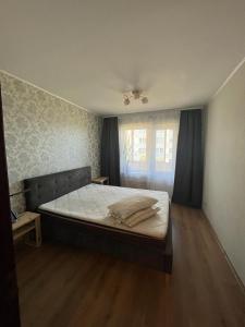 een slaapkamer met een groot bed en een raam bij Atmodas 70 in Jelgava