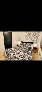 a bedroom with a bed with a black and white comforter at LES ANTHOCYANES in Champagny