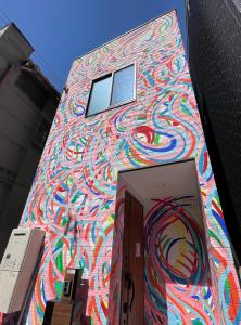 un edificio con una pintura a un lado. en ART HOUSE-アートハウス友家tomoya-, en Osaka
