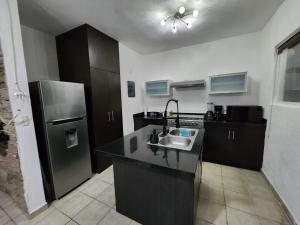 een keuken met een wastafel en een koelkast bij Hermosa Casa en Jardines Cancún in Cancun