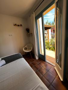 a bedroom with a bed and a sliding glass door at Bungalow Tropical nº6 - Son Xoriguer in Son Xoriguer