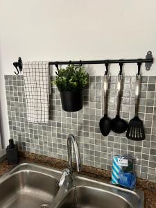 a kitchen sink with utensils on a tile wall at Bungalow Tropical nº6 - Son Xoriguer in Son Xoriguer