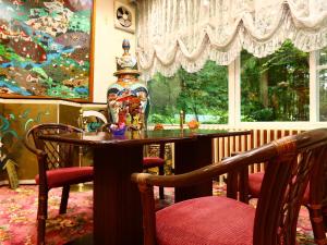 小谷村阳光谷酒店 的一间带桌子和大窗户的用餐室