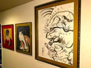 un grupo de pinturas colgando de una pared en ART HOUSE-アートハウス友家tomoya- en Osaka