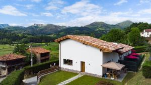an aerial view of a house with mountains in the background at Apartamentos El Respigu in Cangas de Onís