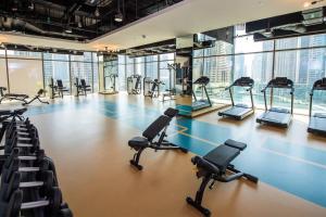 un gimnasio con filas de cintas de correr y bicicletas estáticas en Marina Gate Modern & Unique 1 Bed by AirDHP, en Dubái