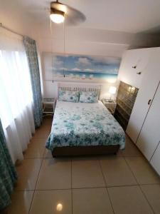 a bedroom with a bed with a blue comforter at Seaview Apartment Amanzimtoti in Amanzimtoti