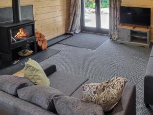 a living room with a couch and a fireplace at West End Lodge in Barmston