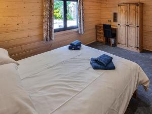 a bedroom with a large bed with two blue towels on it at West End Lodge in Barmston