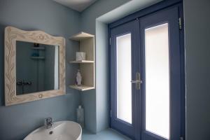 a bathroom with a sink and a mirror at Thea Menetes in Karpathos Town