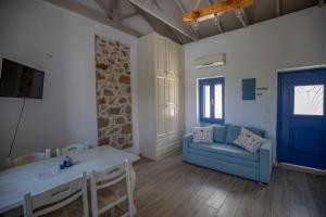 a living room with a blue couch and a table at Thea Menetes in Karpathos Town