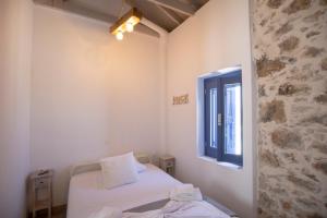 a small room with a bed and a window at Thea Menetes in Karpathos Town