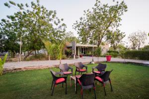 Woodlands Cottage - Luxury stay في جودبور: مجموعة من الكراسي والطاولات في الفناء