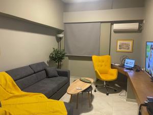 ein Wohnzimmer mit einem Sofa und einem Schreibtisch in der Unterkunft Apartment 55 Fix in Athen