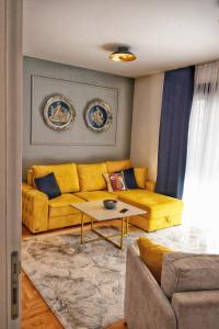 a living room with a yellow couch and a table at The Impressive Apartment in Trebinje