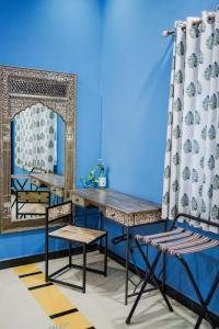 a room with a table and chairs and a mirror at Woodlands Cottage - Luxury stay in Jodhpur