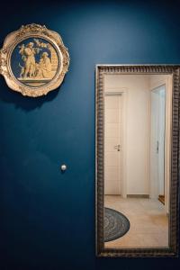 un espejo colgado en una pared azul junto a un pasillo en The Impressive Apartment, en Trebinje