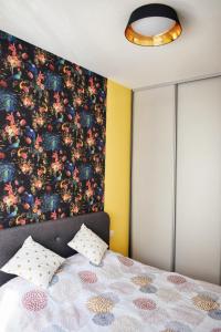 1 dormitorio con 1 cama con pared de flores en The Impressive Apartment, en Trebinje